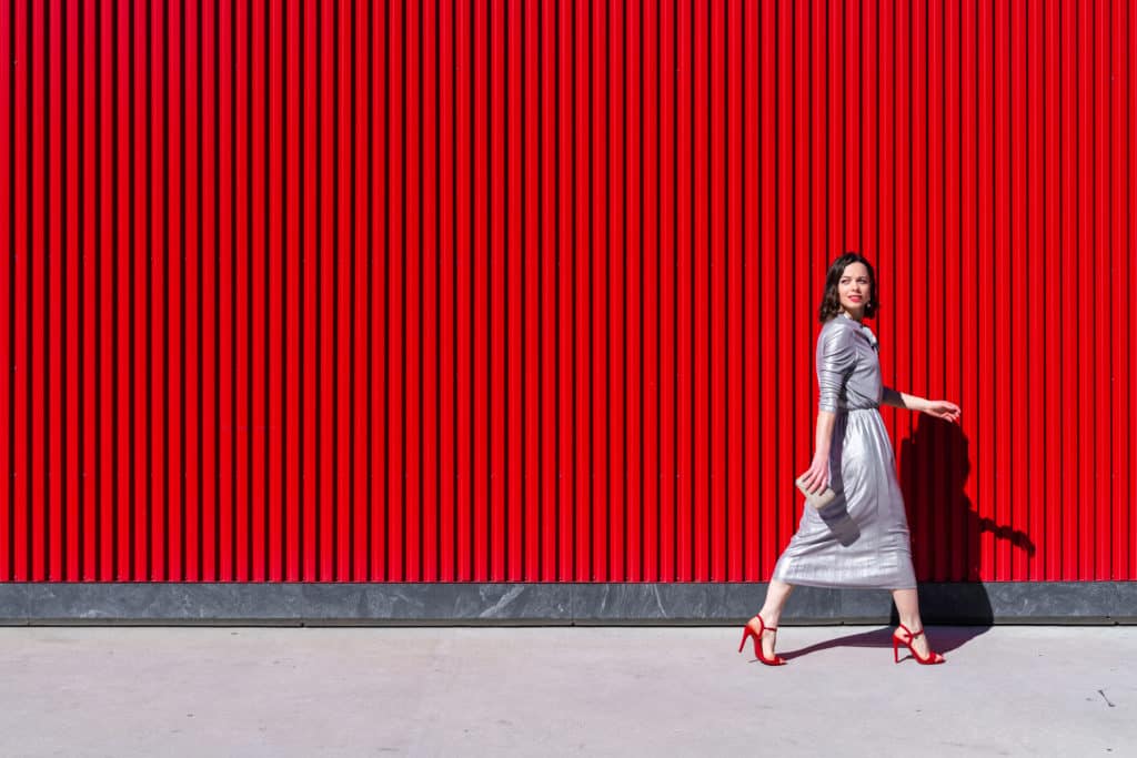 Attractive girl in heels near the red wall