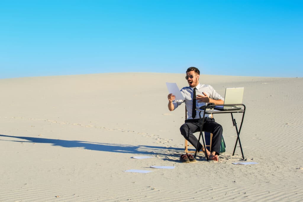 Businessman working and using a laptop in a desert