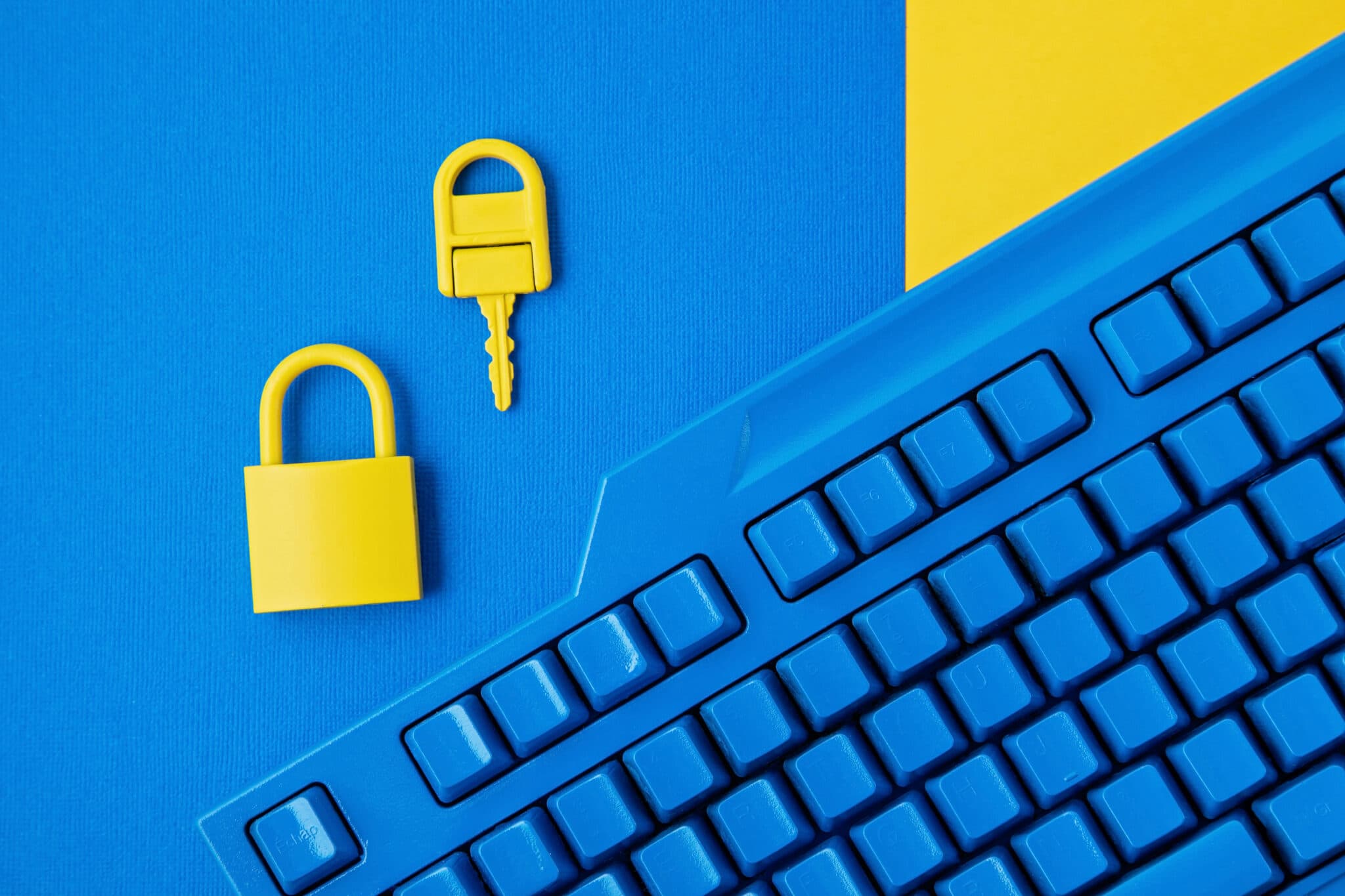 Cyber data and information security idea. Yellow padlock and key and blue keyboard. Computer, information safety, confidentiality concept. Top view, flat lay, mock up