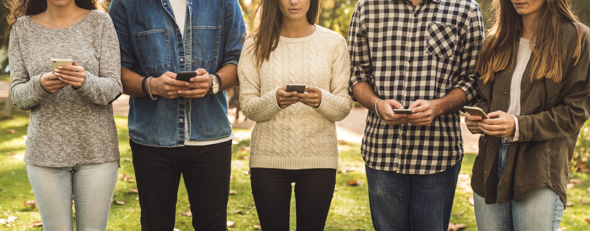 Group of friends distracted with social networks on their phones
