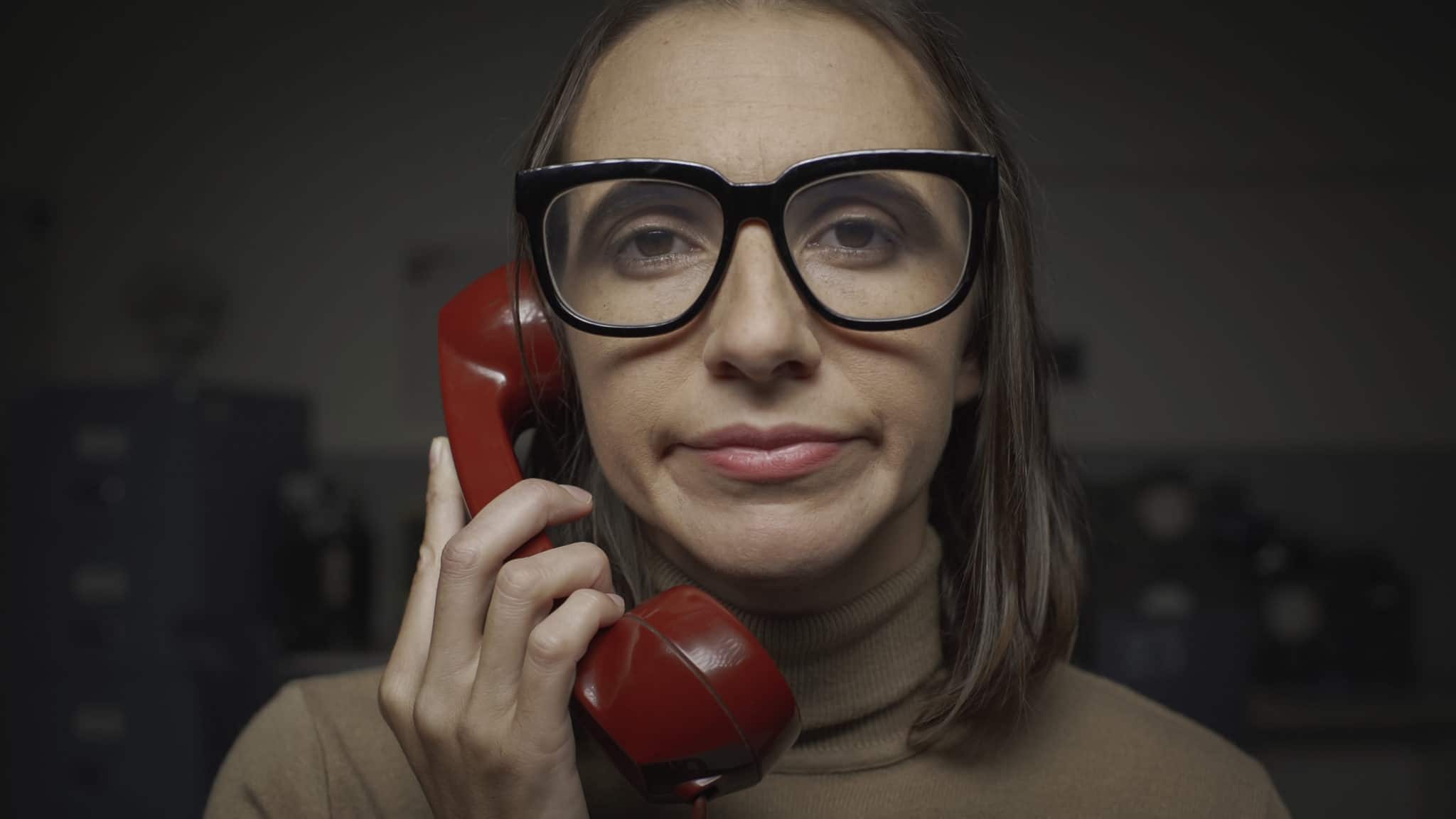 Disappointed woman with glasses having a boring phone call