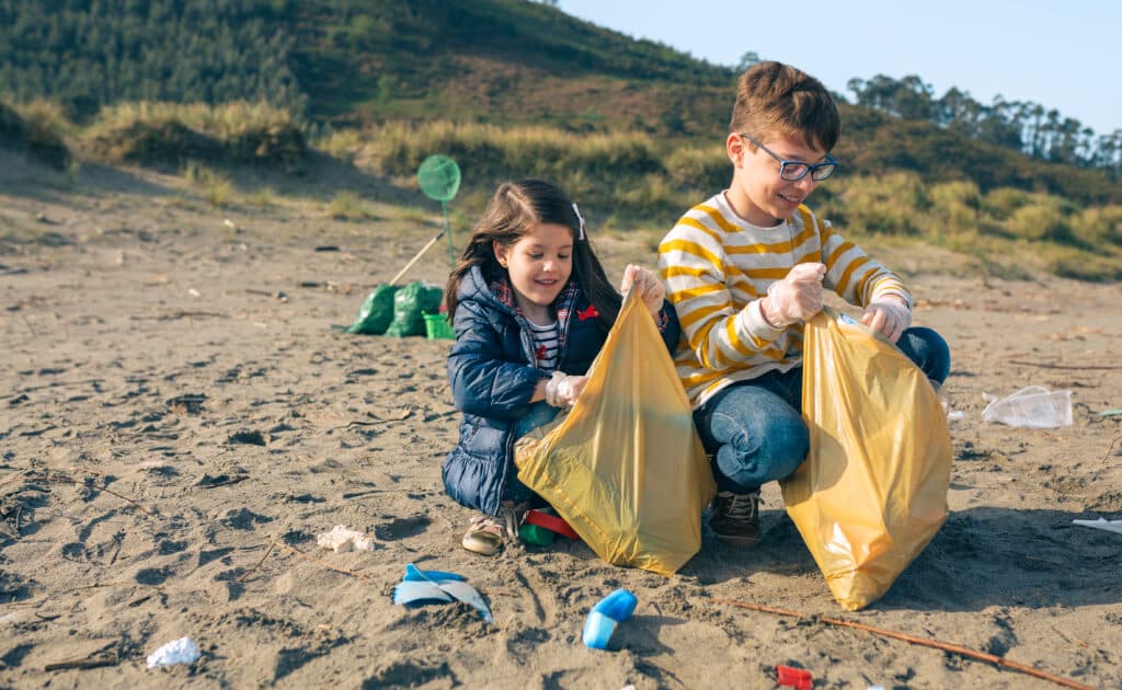 Children volunteers picking up trash on the beach