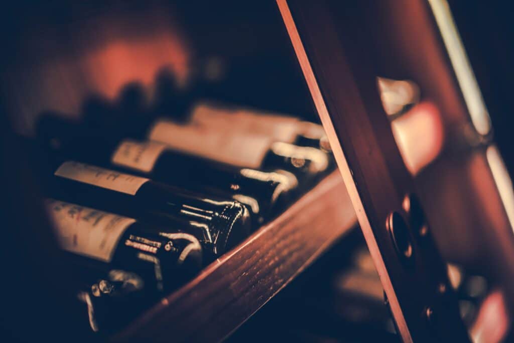 Bottles of Red Wine on the Wooden Shelf. Shallow Depth of Field.