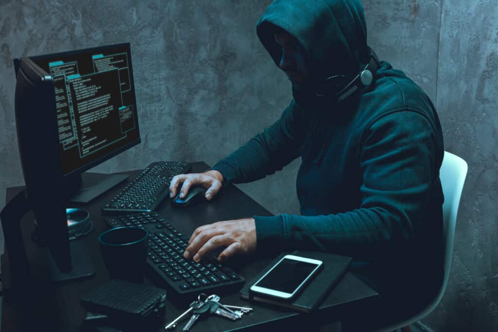 Hacker programmer using computer in dark room, close up