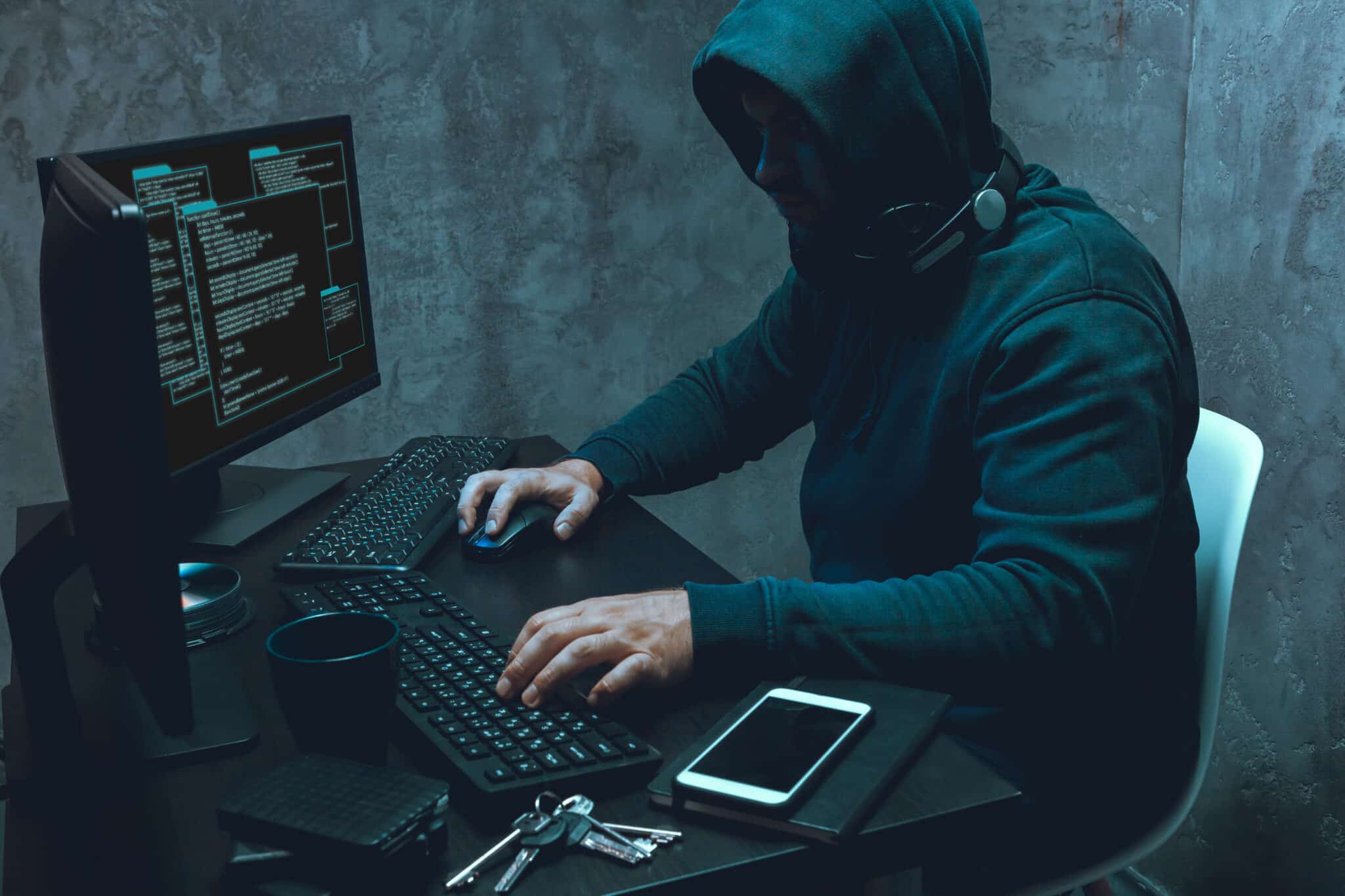 Hacker programmer using computer in dark room, close up