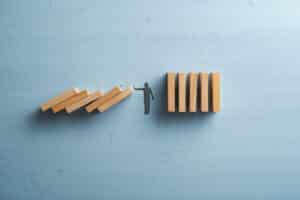A man standing on top of dominoes on a blue background, showcasing the creative skills of web designers.